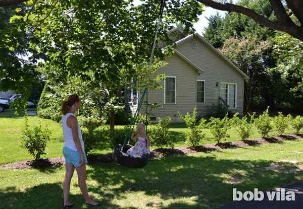 Los niños de bricolaje construyen un swing de neumáticos en el patio trasero